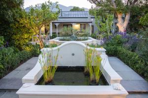 a fountain in the middle of a garden at Macaron Boutique Guest House in Franschhoek