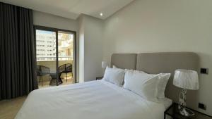 a bedroom with a large white bed and a balcony at Casa Streets 3 BR Terrace - AppartAli Luxury Platform in Casablanca