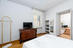 una camera con un letto e un comò con una televisione di Week Mor a La Morra Altre 21 foto