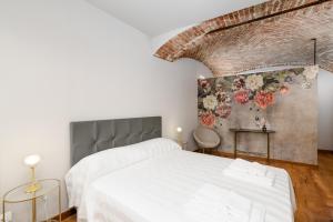 una camera da letto con due letti e un muro di mattoni di Week Mor a La Morra