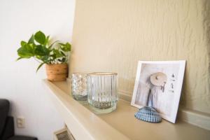 a shelf with a picture and a glass vase on it at Chalet omringd door groen op de Veluwe - Perfect voor gezinnen in Putten