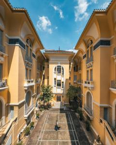 胡志明市Jade Garden by La Doma Express的一名男子坐在一栋建筑庭院的网球场上