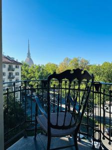 a chair on a balcony with a view of the eiffel tower at Liberty House in Turin