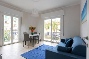 ein Wohnzimmer mit einem blauen Sofa und einem Tisch in der Unterkunft Casa Peonia in Taggia