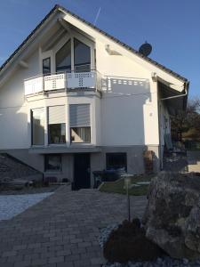 ein weißes Haus mit einem Balkon und einem Felsen in der Unterkunft Ferienwohnung Ahorn in Hohenstein