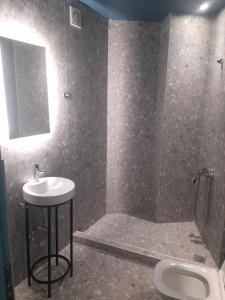 a bathroom with a sink and a shower and a toilet at Mp luxury houses Α3 in Larisa