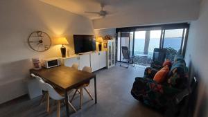 a living room with a table and a couch at Bungalow Uno - Front Line of Ocean in San Bartolomé de Tirajana
