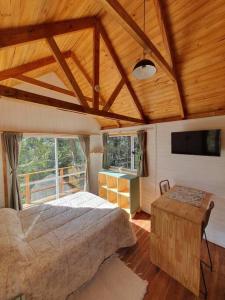 una camera con un grande letto e una grande finestra di Tiny House en el bosque a San Carlos de Bariloche