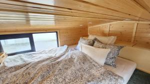 a bed in a small room with a window at Behagliches OFFGRID Tiny House - Escape to Nature in Sankt Pölten