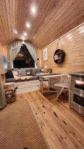 a living room with a couch and a table at Behagliches OFFGRID Tiny House - Escape to Nature in Sankt Pölten +10 photos