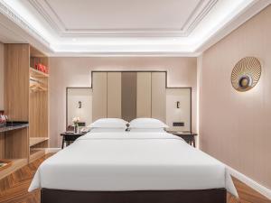 Łóżko lub łóżka w pokoju w obiekcie 锦江都城 新沂行政中心北京路店
