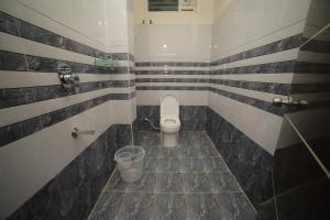 a bathroom with a toilet and a trash can at Sri Ganesh Residency in Tirupati +10 photos