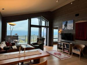 a living room with a couch and a table and a television at Riddertunets atmosfære in Beitostøl