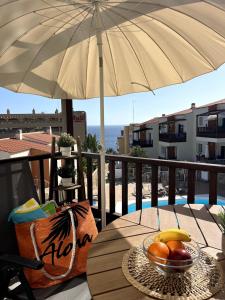 a bowl of fruit sitting on a table under an umbrella at Aloha Apartman Arguineguin in Arguineguín