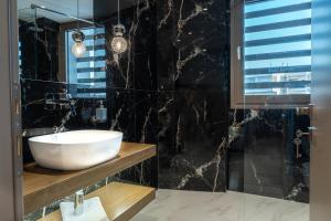 a bathroom with a sink and a glass shower at Sky Hotel in Perea +49 photos