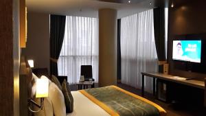 イスタンブールにあるLivello Hotelのベッド1台、薄型テレビが備わるホテルルームです。