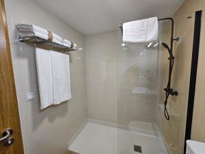 Un baño con ducha con puerta de cristal. en Apartamento Nara Playa, en Boiro 16 fotos más