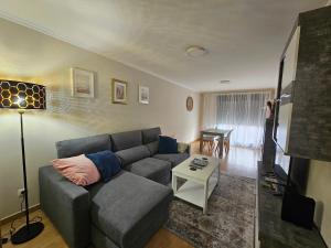una sala de estar con un sofá y una mesa en Apartamento Nara Playa, en Boiro