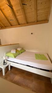 a bed in a room with a wooden ceiling at Villa rustica bougainvillea in Maslinica