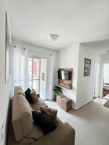 a living room with a couch and a tv at Apartamento Paris in São José dos Pinhais +20 photos