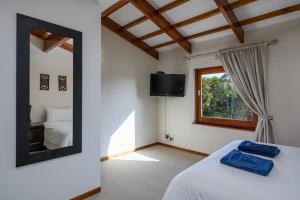 a bedroom with a mirror and a bed and a window at San Lameer Villa's in Southbroom +41 photos