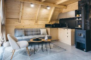 a living room with a couch and a table and a kitchen at LandHaus Tri Vikendice in Risovac