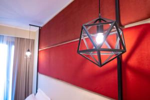 a lamp hanging from a red wall in a bedroom at Best Western Plus Sabaudia Hotel in Sabaudia