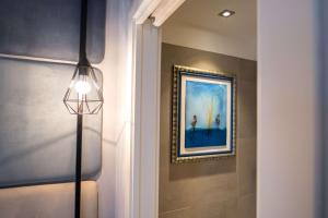 a hallway with a painting on the wall and a lamp at Best Western Plus Sabaudia Hotel in Sabaudia