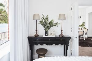 a black table with two lamps on top of a fireplace at Exclusive Darling Apt Harbour View Balcony in Sydney