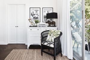 a white room with a chair and a desk at Exclusive Darling Apt Harbour View Balcony in Sydney