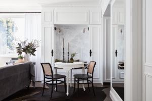 a dining room with a white table and chairs at Exclusive Darling Apt Harbour View Balcony in Sydney