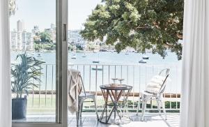 a balcony with a table and chairs and a view of the water at Exclusive Darling Apt Harbour View Balcony in Sydney