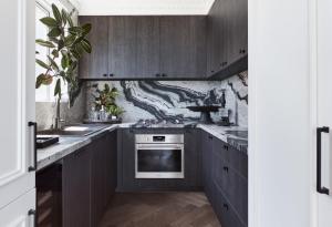a kitchen with dark wood cabinets and a stove at Exclusive Darling Apt Harbour View Balcony in Sydney +10 photos