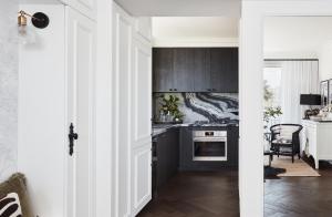 a kitchen with black cabinets and a stove top oven at Exclusive Darling Apt Harbour View Balcony in Sydney