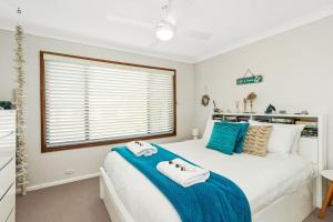 a bedroom with a bed with towels on it at Family Coastal Escape Narrawallee NSW in Narrawallee