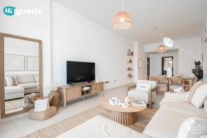 un salon avec un canapé et une télévision dans l'établissement HiGuests - Premier Beachfront Stylish 2BR Apt Plus Maid Room, à Dubaï