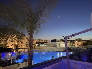 a pool on the roof of a building with a palm tree at Dream Gardens 2 in Mijas Costa