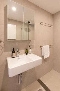 a bathroom with a white sink and a shower at 2BDR Brand New Apt Moments from RNSh St Leonards in Sydney