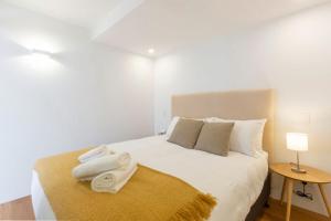 a bedroom with a white bed with towels on it at 2BDR Brand New Apt Moments from RNSh St Leonards in Sydney