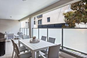 a dining room with a table and chairs on a balcony at Coastal Retreat in the Heart of Kiama in Kiama