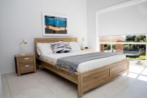 een slaapkamer met een groot bed en een groot raam bij Blissful Stay Moments From the Beach in Surf Beach
