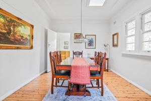 Un comedor con mesa y sillas en Deodar Cottage Amid Century Old Trees, en Wentworth Falls