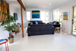 a living room with a couch and a table at Blissful Stay Moments From the Beach in Surf Beach