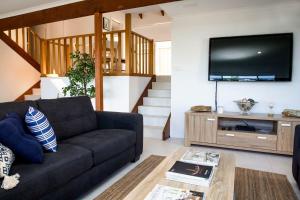 een woonkamer met een bank en een flatscreen-tv bij Blissful Stay Moments From the Beach in Surf Beach