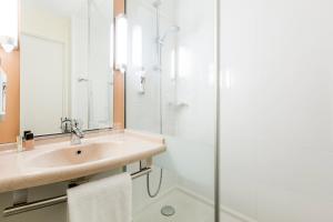 ein Badezimmer mit Waschbecken und Dusche in der Unterkunft ibis Rennes Cesson in Cesson-Sévigné + 50 Fotos
