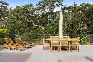 a wooden table and chairs on a patio at Hillside Hamptons Indoor Fire and Fire Pit in Terrigal