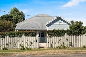 a white house with a white picket fence at Blue Wren Cottage on Edith - A Fireside Retreat in Wine Country in Cessnock