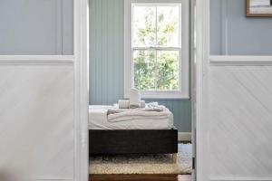 a room with a bed and a window at Blue Wren Cottage on Edith - A Fireside Retreat in Wine Country in Cessnock