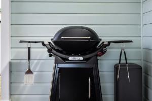 a barbecue grill sitting against a wall at Blue Wren Cottage on Edith - A Fireside Retreat in Wine Country in Cessnock