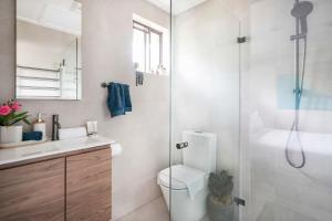 a bathroom with a shower and a toilet and a sink at Oak Retreat Bliss by the Beach in Warriewood +22 photos